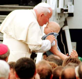 Papie� uca�owa� dziecko przed wej�ciem na pok�ad samolotu. 
Fot. PAP/Adam Hawa�ej